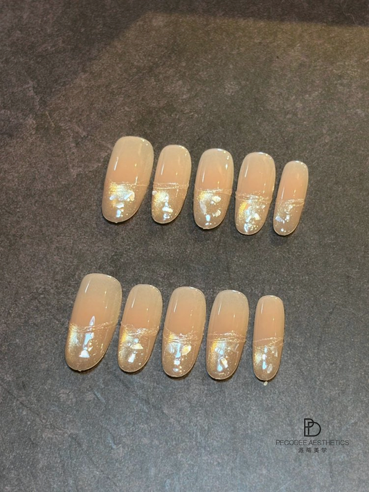 Gold foil acrylic nails set with nude glossy finish, short oval shape.
