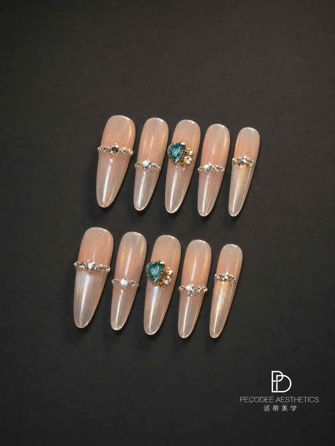 Glossy peach acrylic nails set with pearl and aqua gemstone embellishments, almond shape