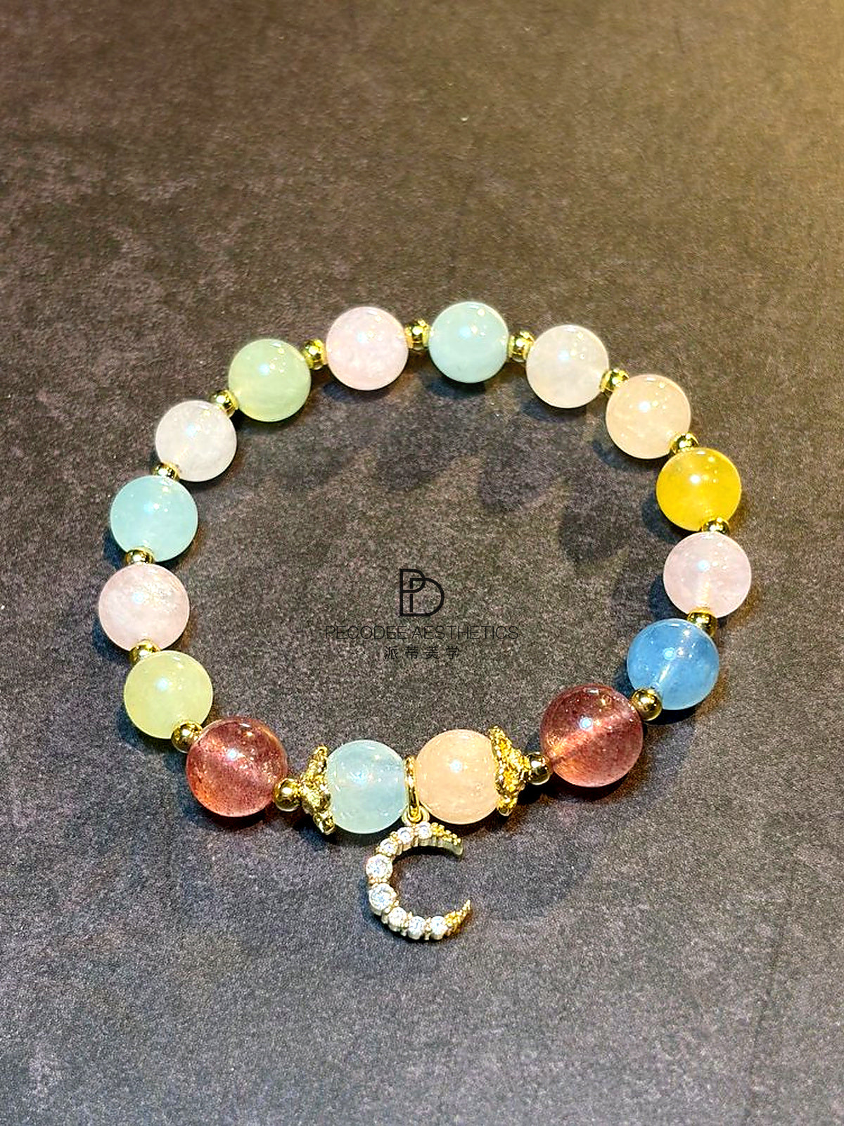 Multicolor beaded crescent bracelet with gold links and dangling rhinestone charm