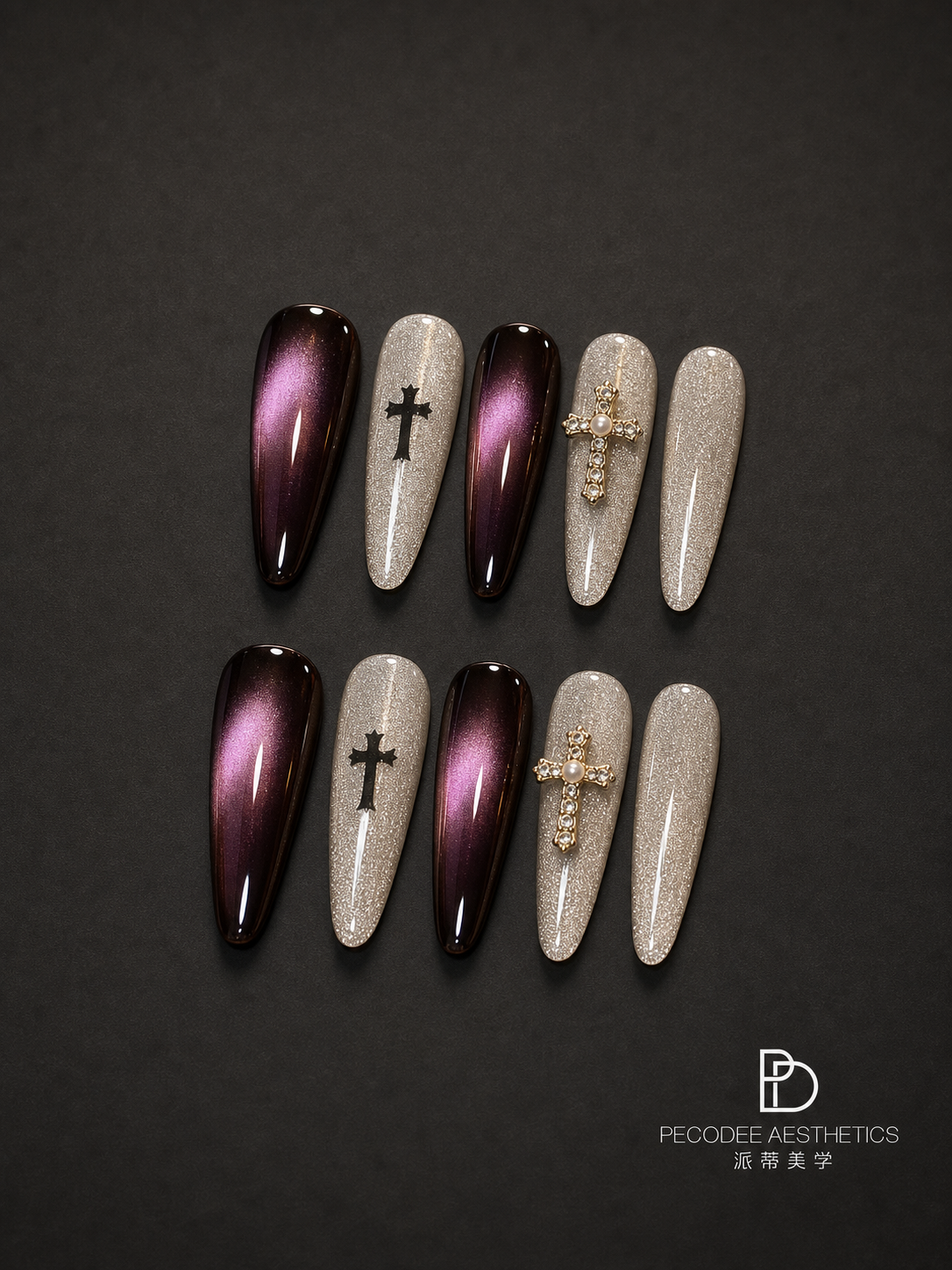 Burgundy press-on nails with glitter tips, cross charms, and rhinestone details