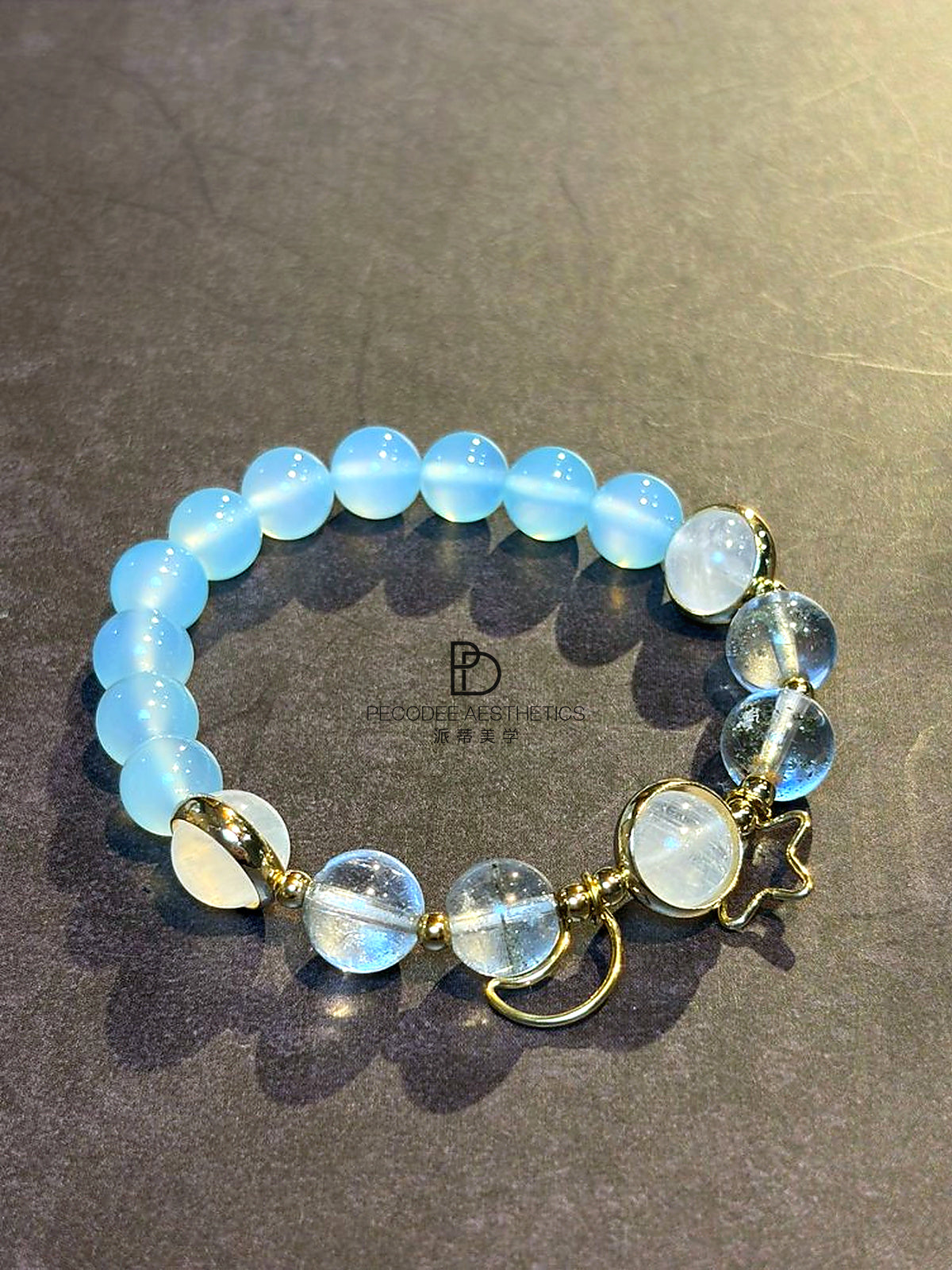Blue beaded bracelet with gold-tone clasps and round charm dangles