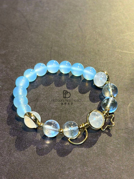 Blue beaded bracelet with gold-tone clasps and round charm dangles
