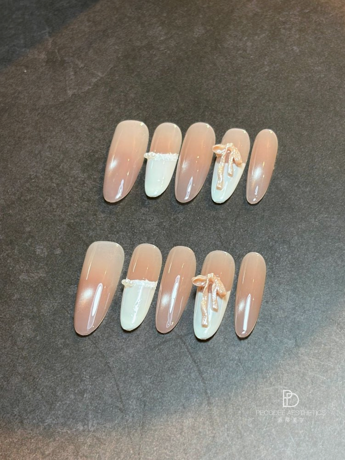 Cream bow nail set with pale nude and white tips, bow accents on two nails