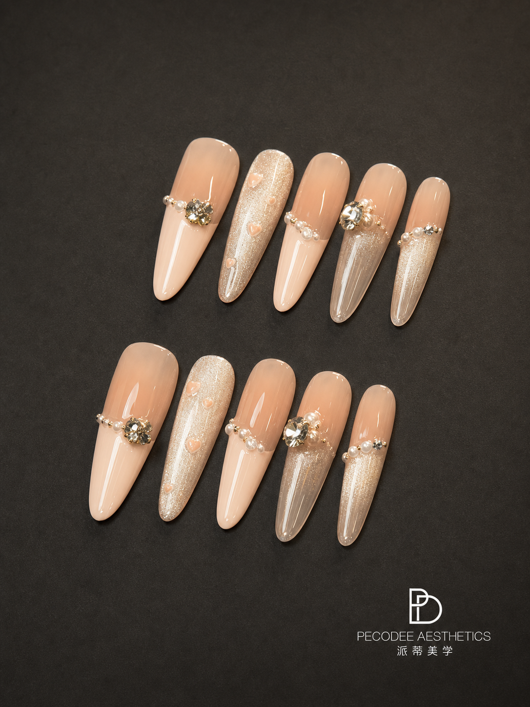 Cream almond nails with pearl and gold rhinestone accents