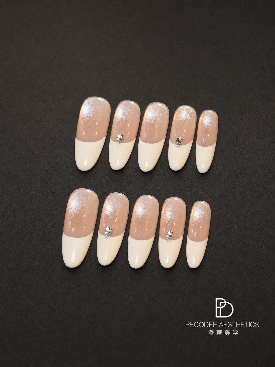Cream satin manicure nails with glossy cream base, white tips, and small rhinestone details