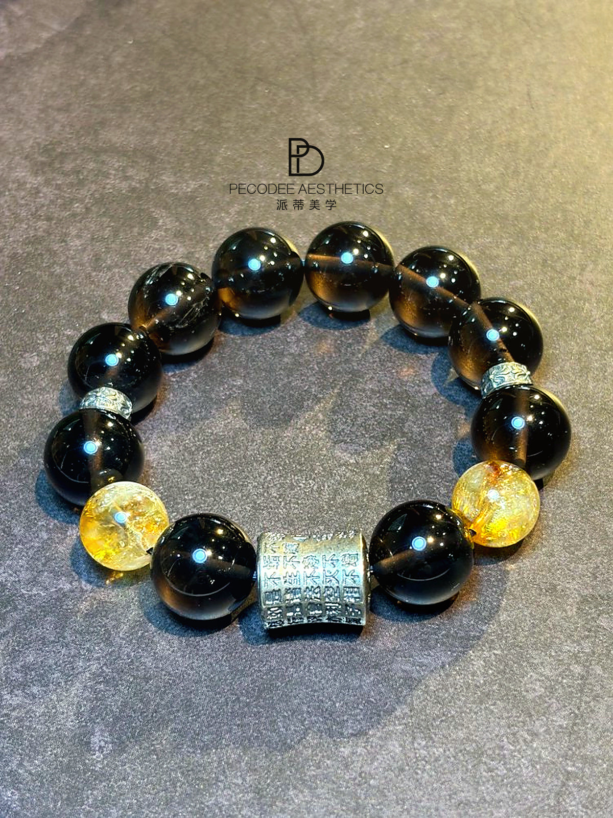 Beaded bracelet with dark round beads, gold accents, and a rectangular centerpiece