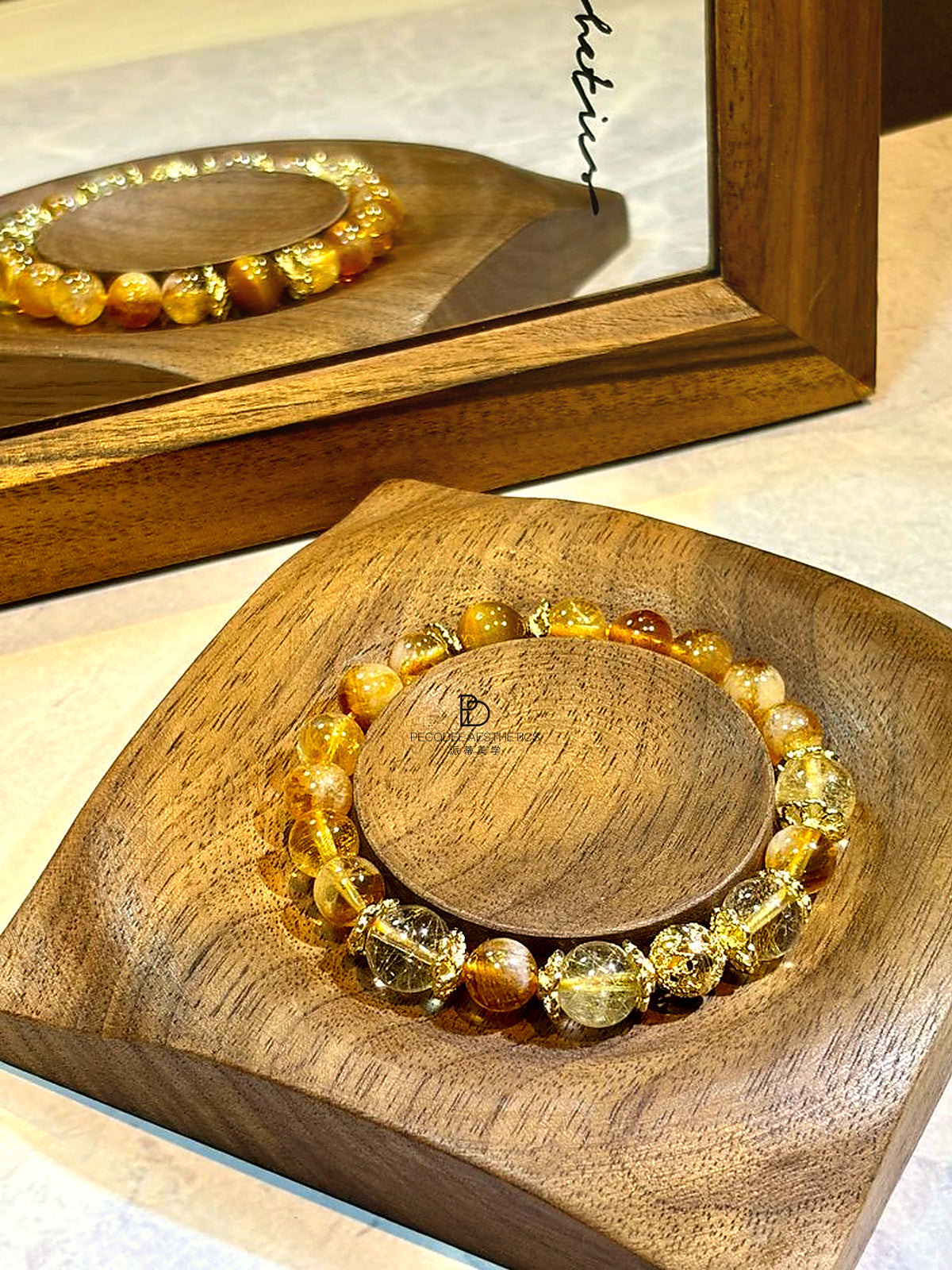 Amber beaded bracelet in a circular display, clear and honey-gold bead mix