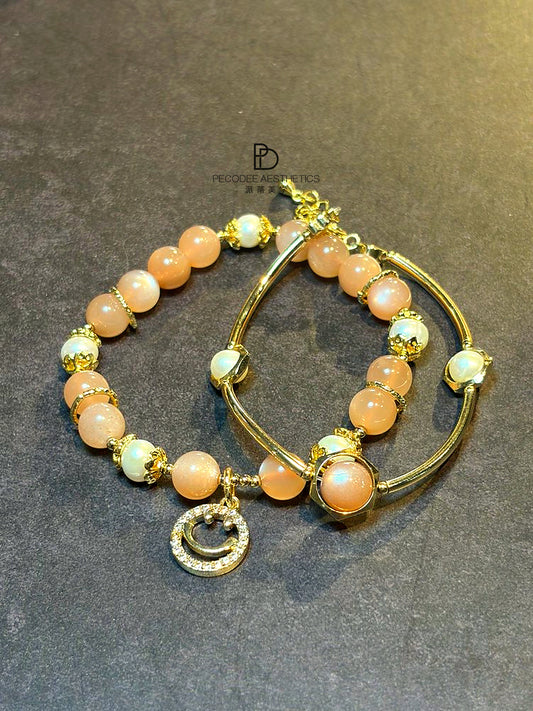 Gold-tone beaded pearl bracelet set with orange and white pearls, hoop bangles, charms