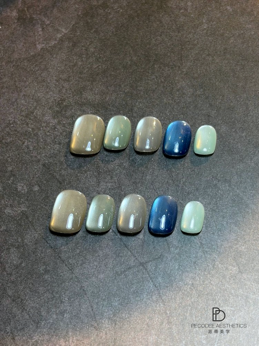 Assorted nail tips with blue, aqua, and nude gel shades, glossy finish