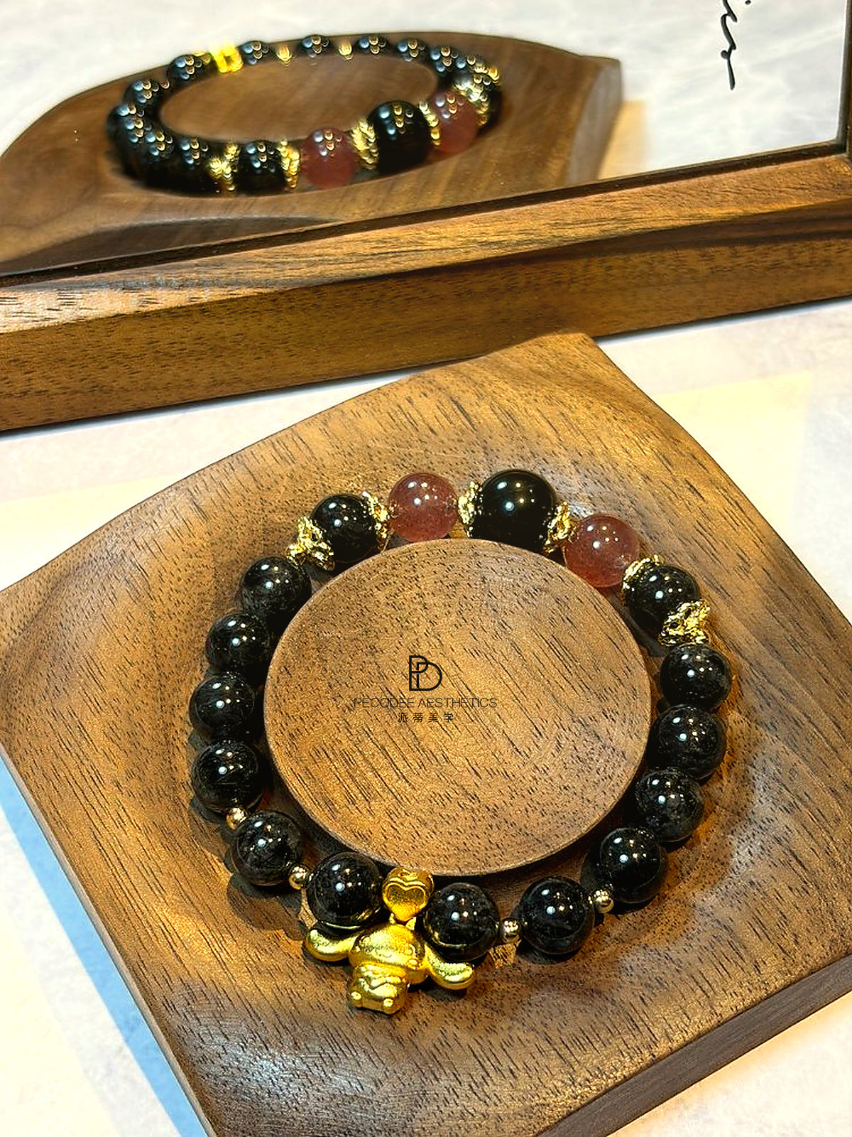 Dark beaded bracelet with gold-tone charm and brown accent beads