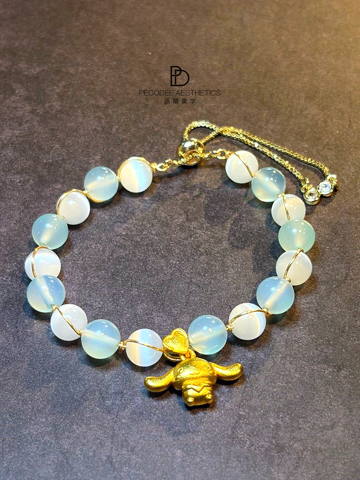 Opal-like bead bracelet with pale blue and white oval stones, gold charm and clasp