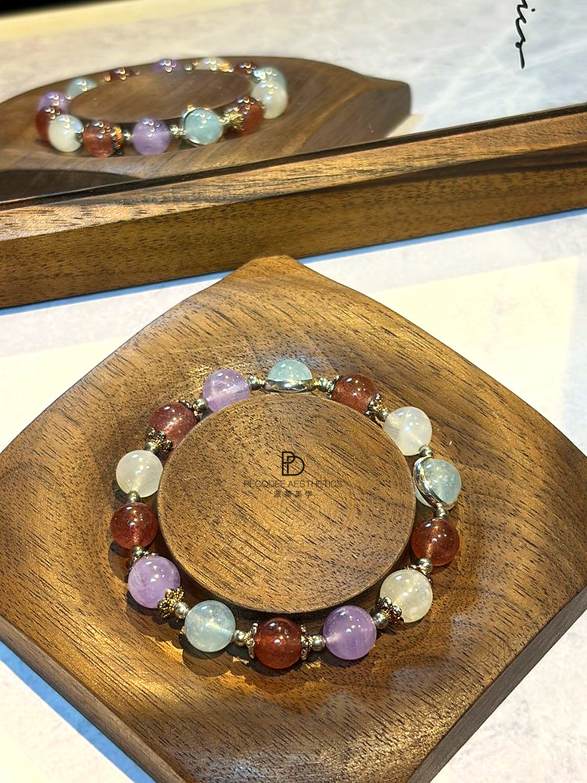 Beaded gemstone bracelet on wooden display, multicolor round beads with gold spacers