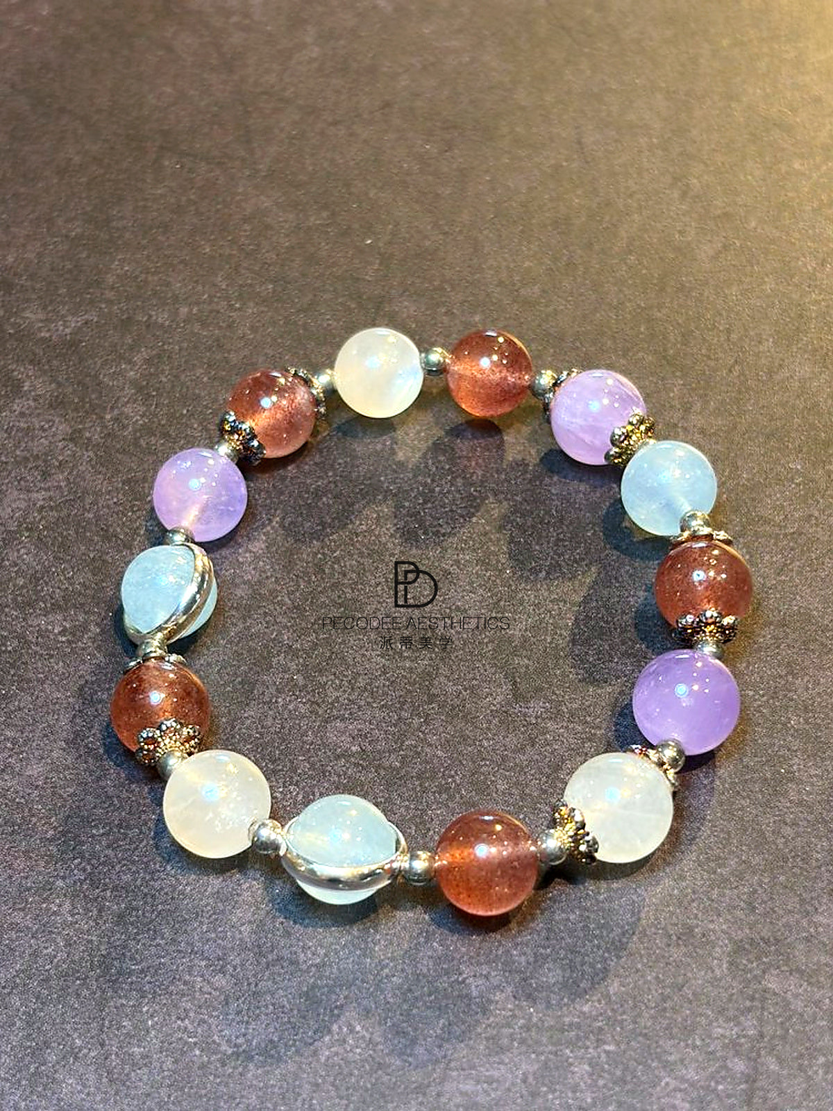 Beaded gemstone bracelet with purple, blue, and amber round beads and gold accents