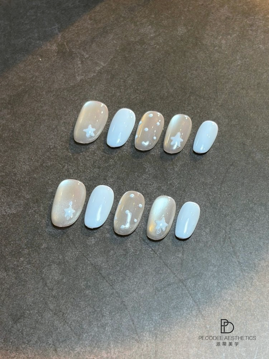 Set of pastel blue and nude nail tips with star and glitter accents